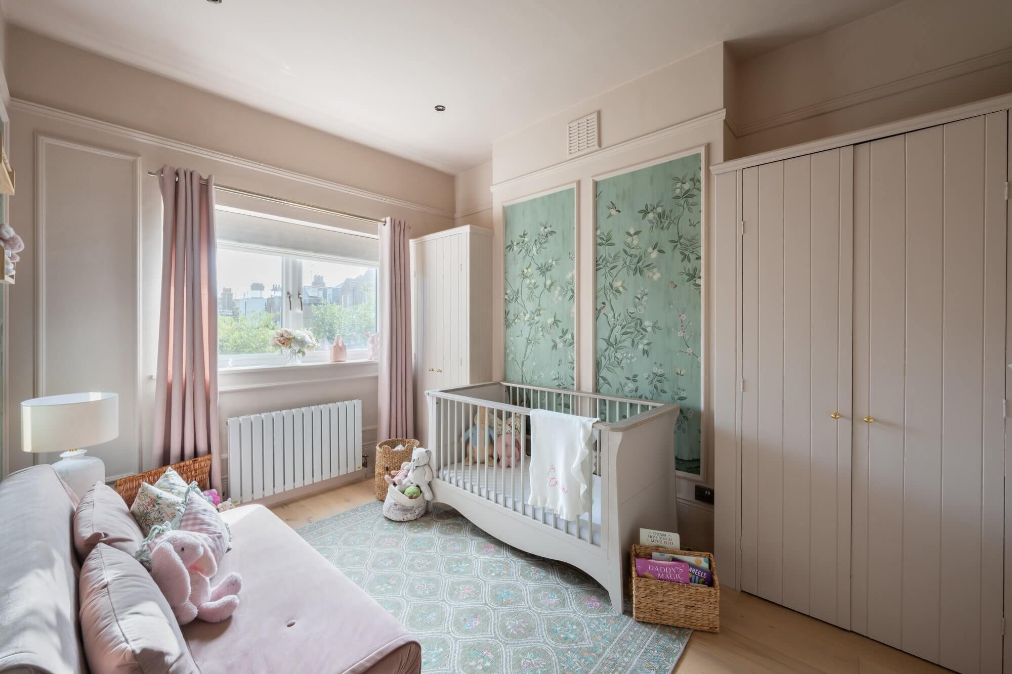 Whimsical nursery and playroom — cot and hand-painted wallpaper panels